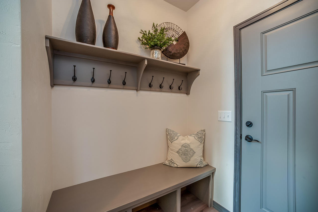 Nice and cozy mudroom entry way with a shade of green door